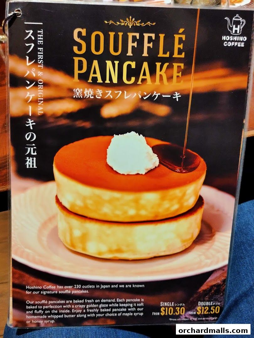 A menu featuring Hoshino Coffee's signature soufflé pancakes with syrup being poured.