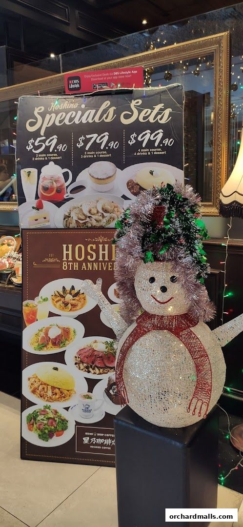 A festive display featuring Hoshino Coffee's special sets and a sparkling snowman.