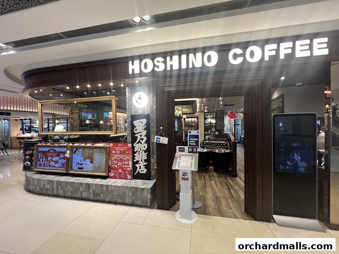 The entrance of Hoshino Coffee at ION Orchard, featuring its prominent signage and display of menu items.