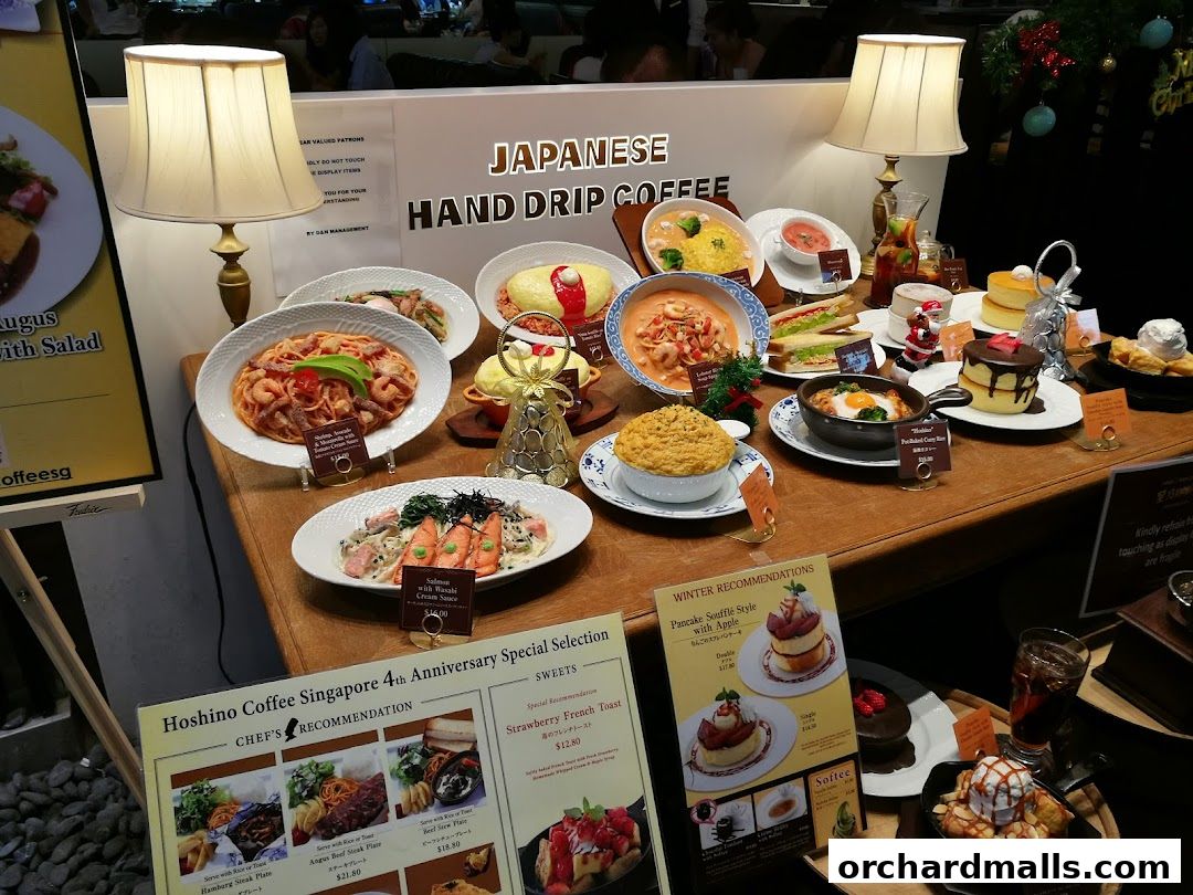 A display of various Japanese dishes and desserts, including pasta, omelets, sandwiches, and cakes.