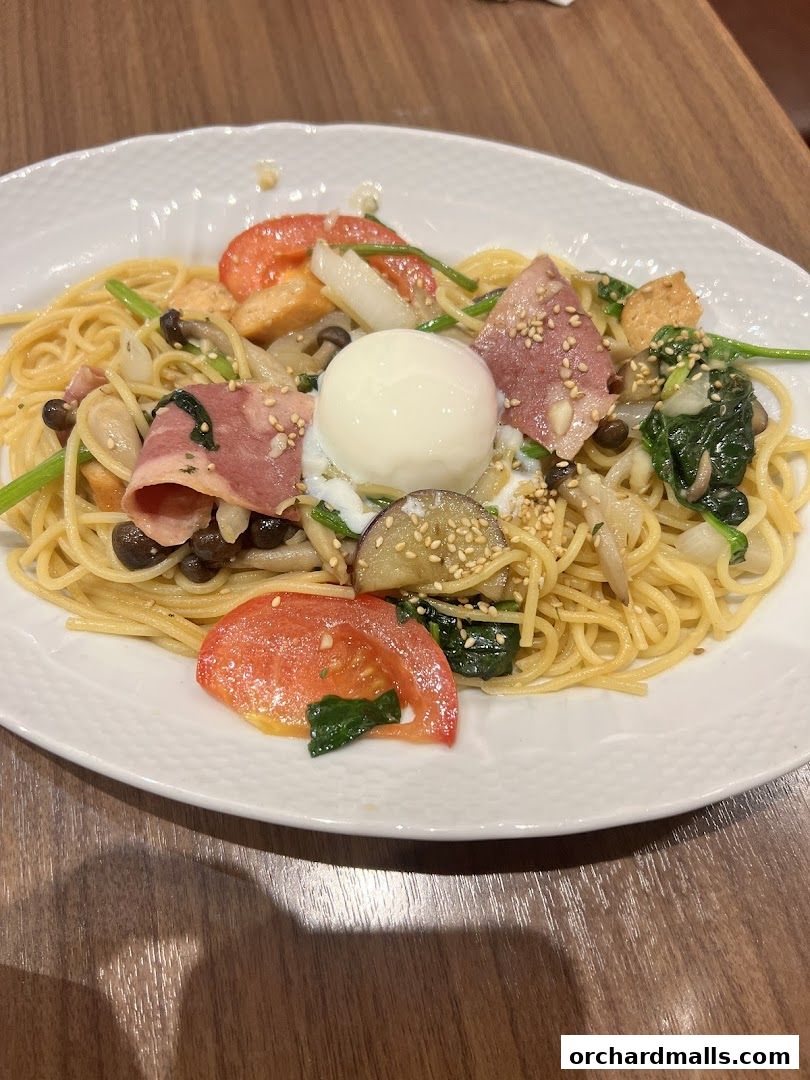 A plate of spaghetti with a poached egg, bacon, mushrooms, spinach, and tomatoes.