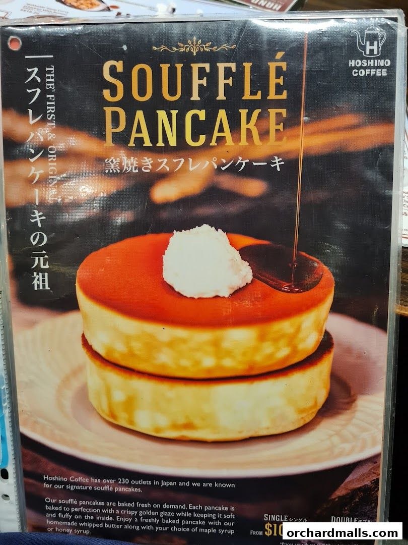 A menu featuring Hoshino Coffee's signature soufflé pancakes with syrup being poured.
