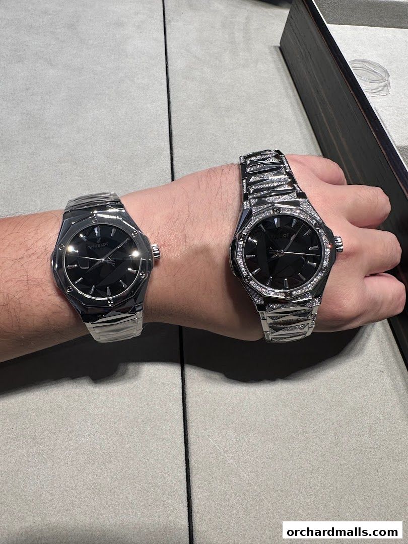Two Hublot watches are displayed on a person's wrists, one with diamonds.