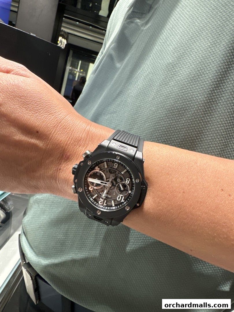 A close-up shot of a person wearing a black Hublot watch on their wrist.
