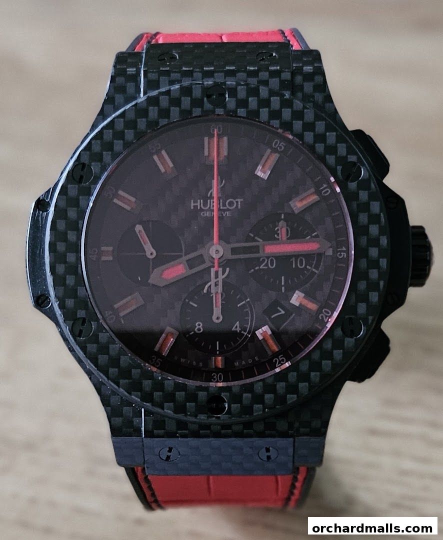 A close-up shot of a Hublot watch with a carbon fiber case and red accents.