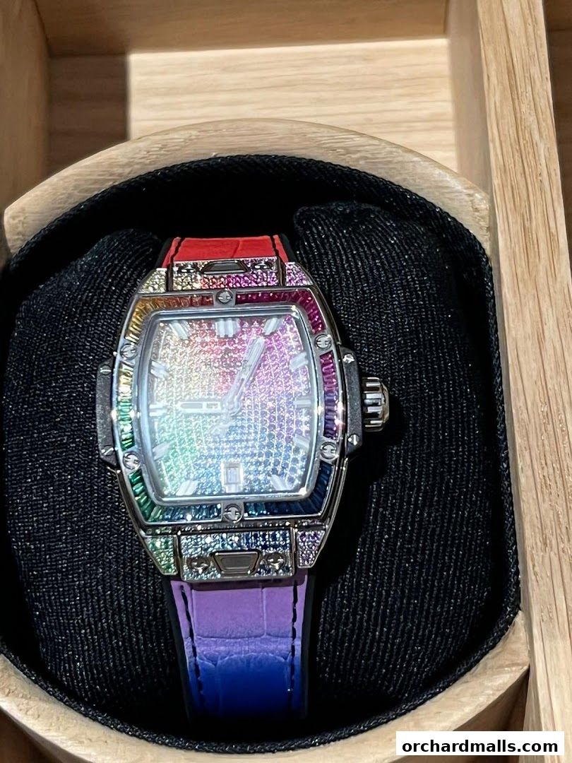 A close-up of a luxurious Hublot watch with a rainbow-colored gem-encrusted bezel and strap.