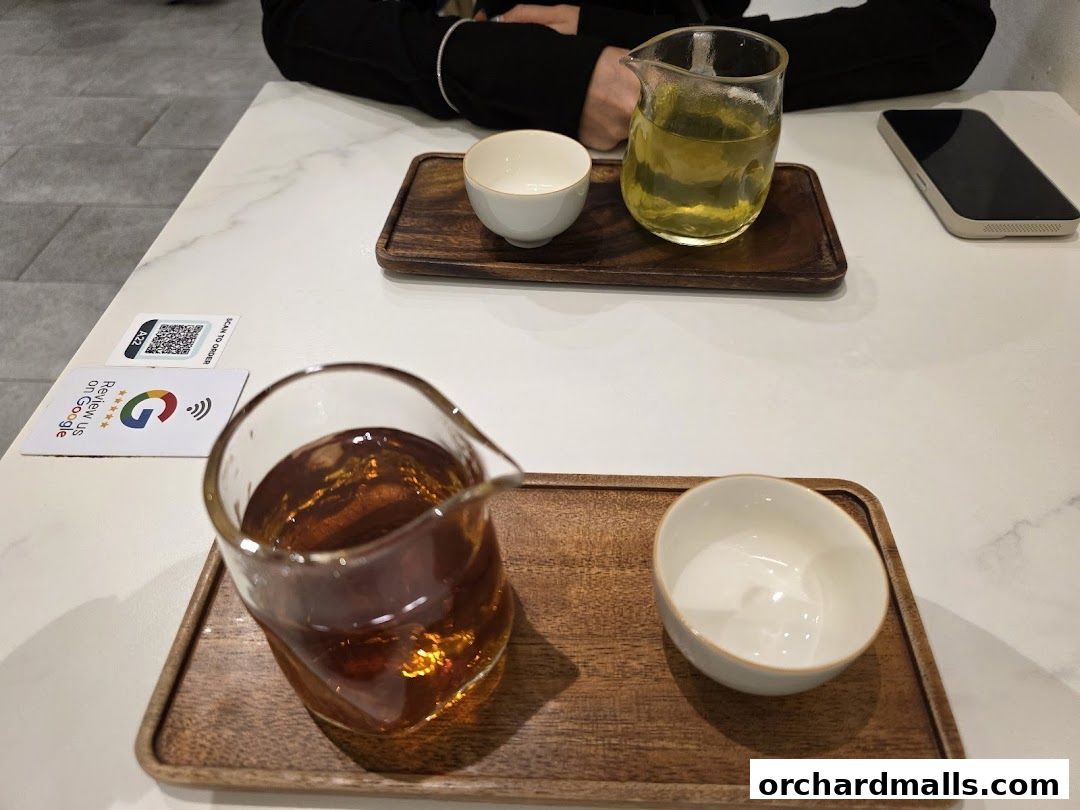 Two servings of tea are presented on wooden trays with small white bowls.