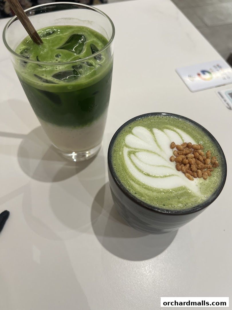 Two delicious matcha drinks, one iced and one hot, are presented on a white table.