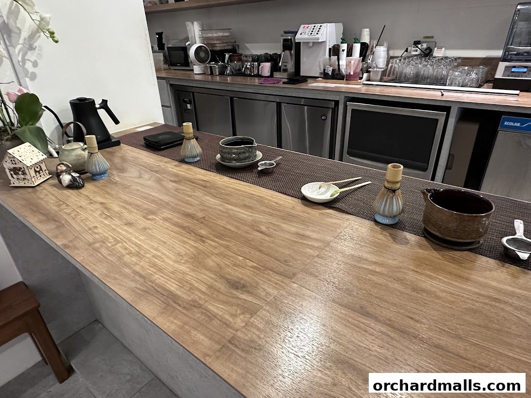 A wooden counter with matcha tea preparation tools and decorative items.
