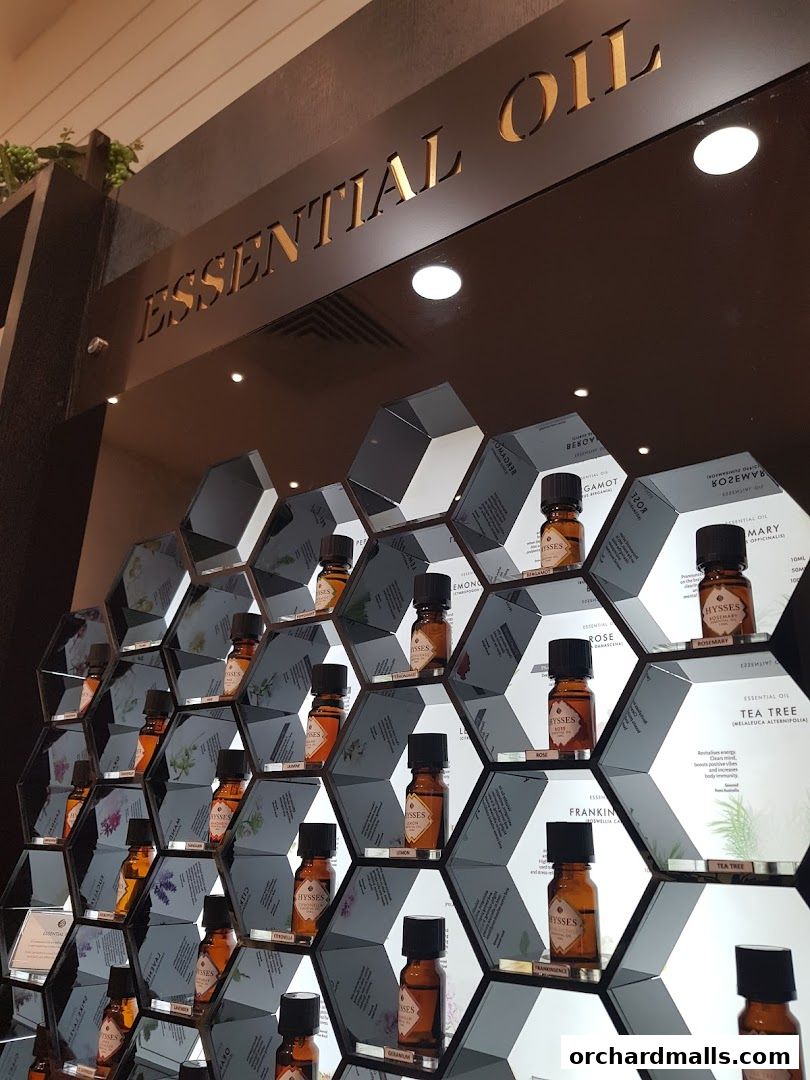 A display of essential oil bottles arranged in a honeycomb pattern on shelves.