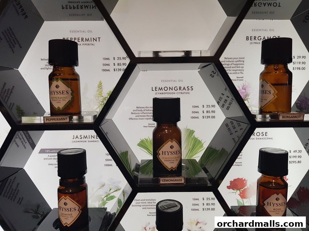 A display of essential oil bottles with labels and prices in hexagonal compartments.