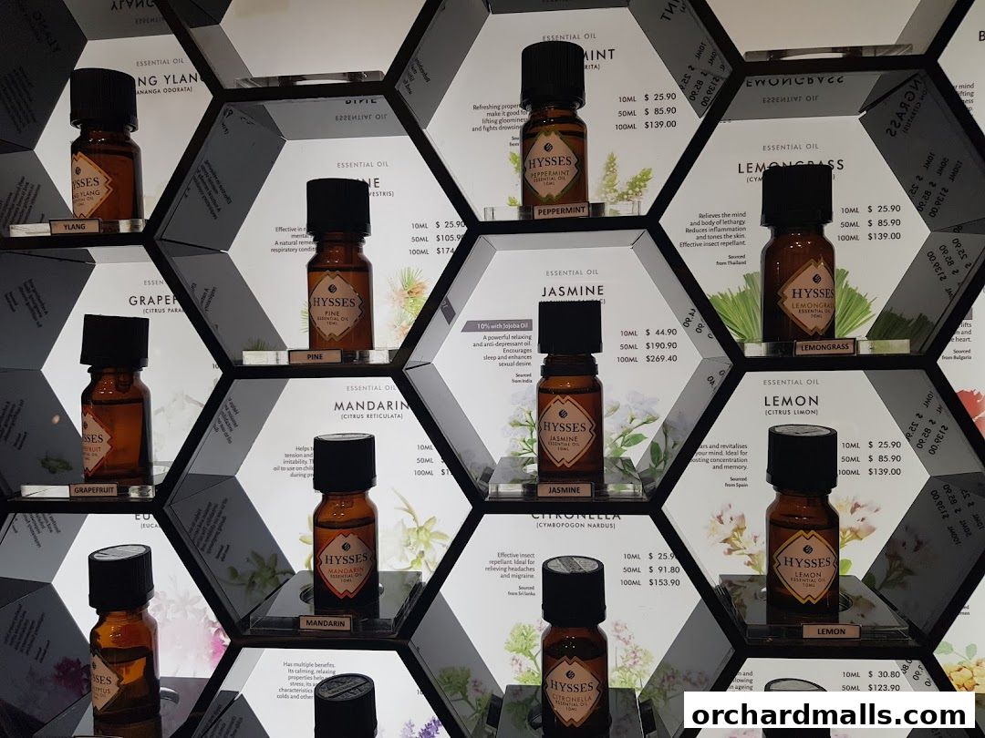 A display of various essential oil bottles arranged in a honeycomb pattern on shelves.