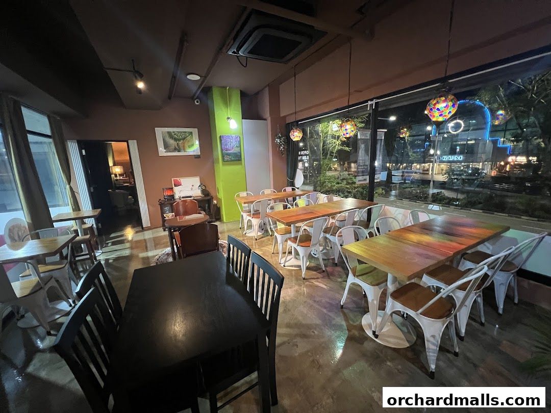 Interior of a restaurant with tables, chairs, and a view of the city at night.