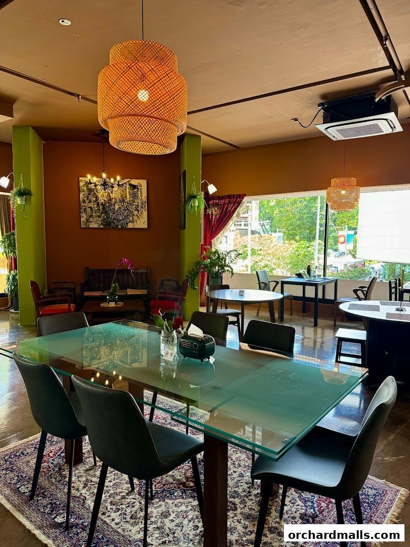 Interior of a restaurant with tables, chairs, and decorative lighting.