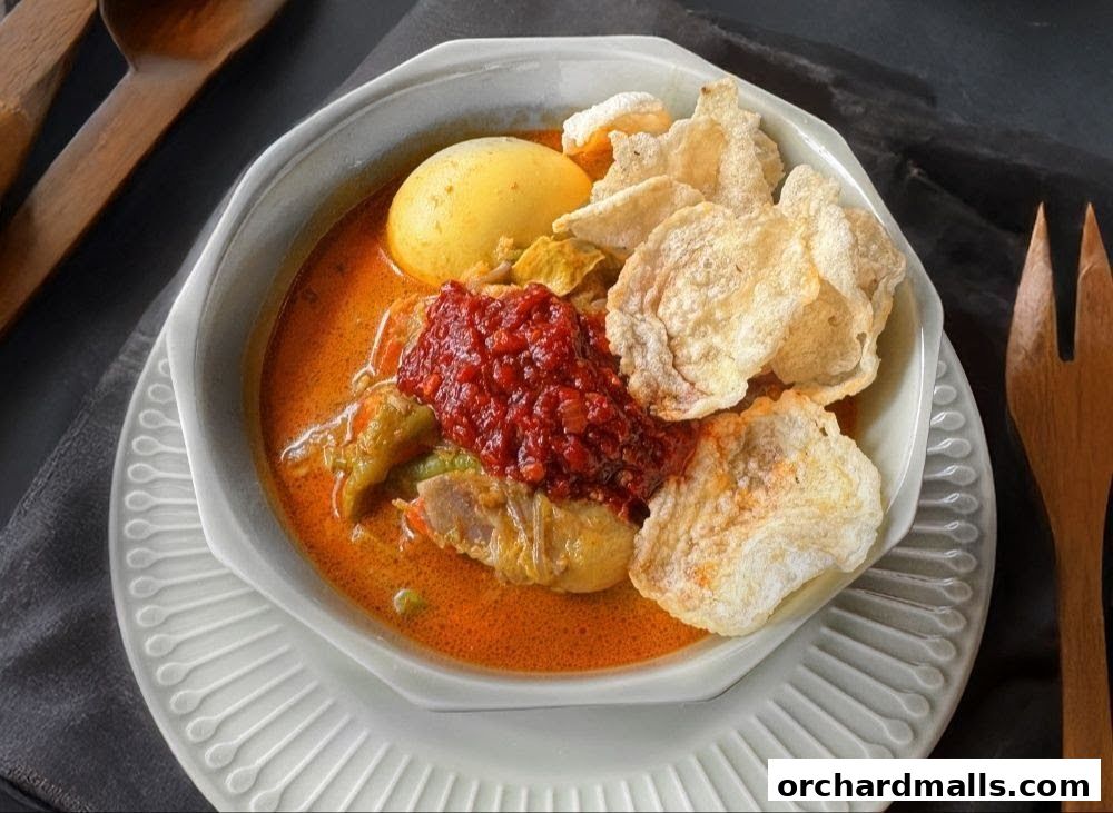 A close-up of a delicious Indonesian dish with rice cakes, egg, and chili paste.