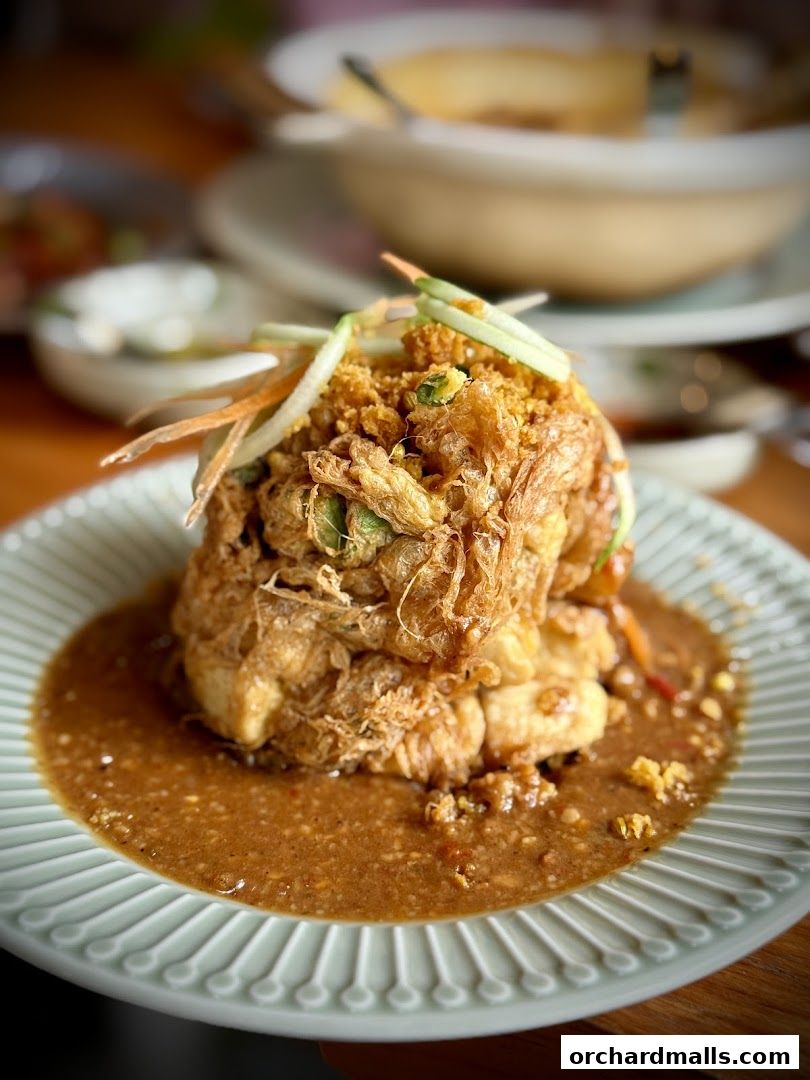 A close-up of a delicious dish with crispy fried tofu and a savory sauce.