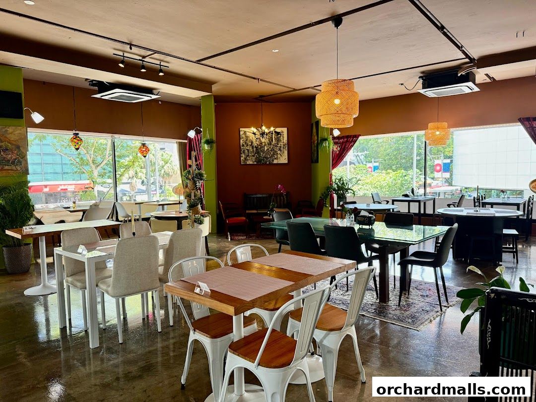 Interior view of a restaurant with tables, chairs, and decorative lighting.