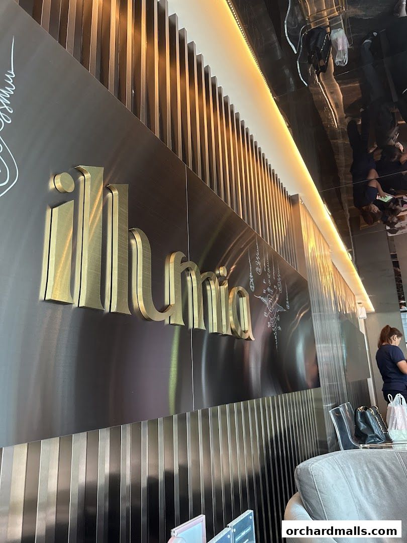 The illuminated 'illumia' logo on a metallic wall with vertical accents.