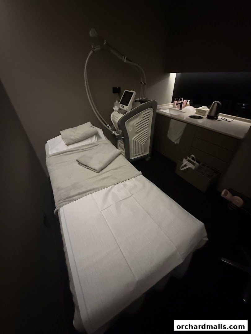 A treatment bed and medical spa equipment in a dimly lit room.