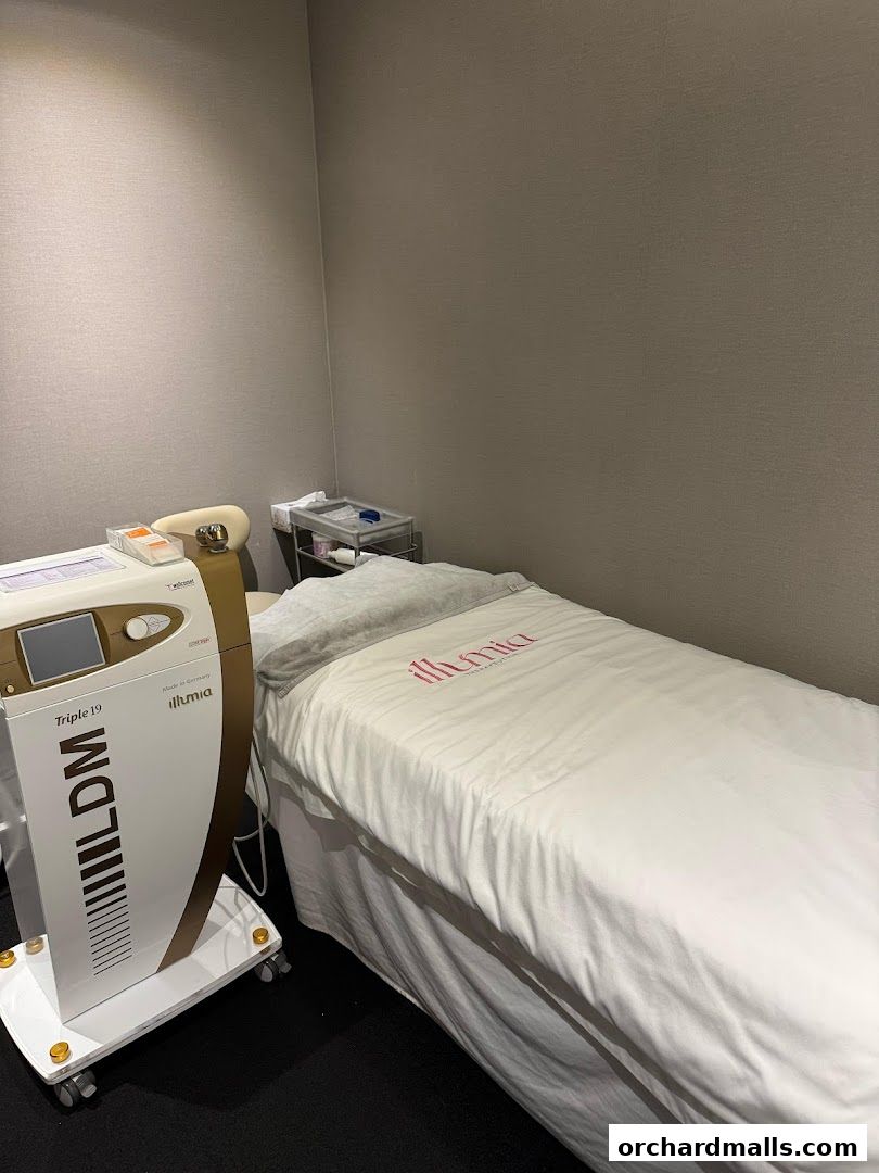 A treatment bed and medical device in a clean, modern spa room.