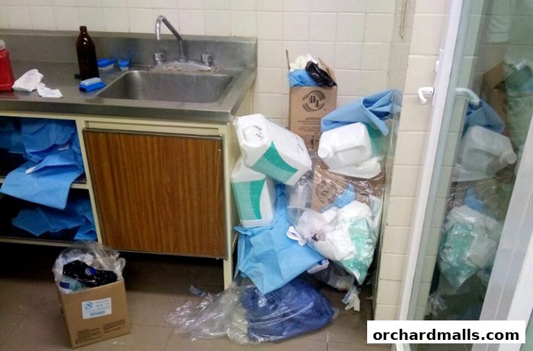 A sink area with cleaning supplies and medical disposables piled up.