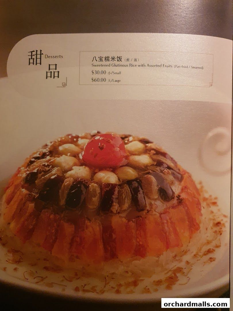 A close-up of a menu item featuring a dessert of sweetened glutinous rice with assorted fruits.