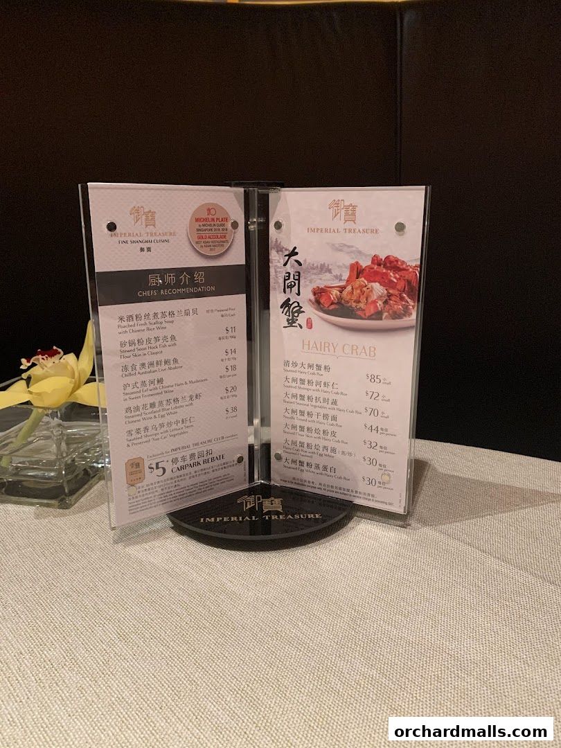 A table display featuring menus for Imperial Treasure Fine Shanghai Cuisine, highlighting chefs' recommendations and hairy crab dishes.