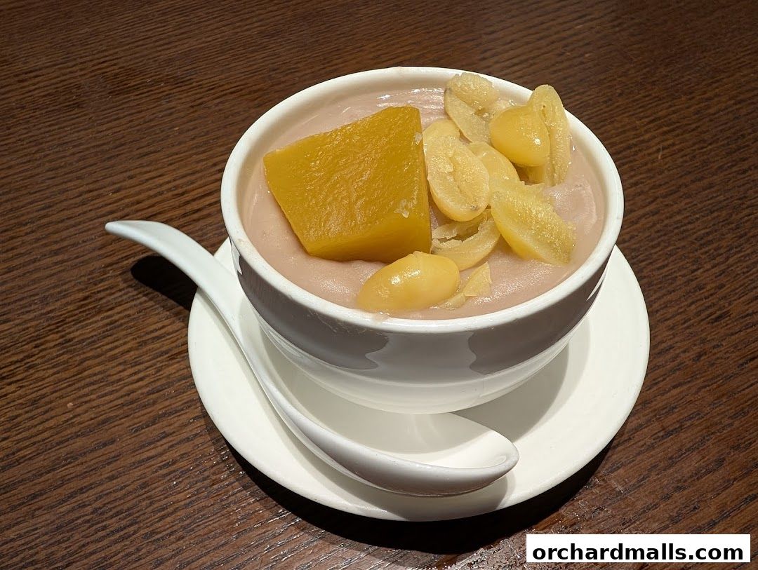 A close-up of a bowl of taro dessert with pumpkin and ginkgo nuts.