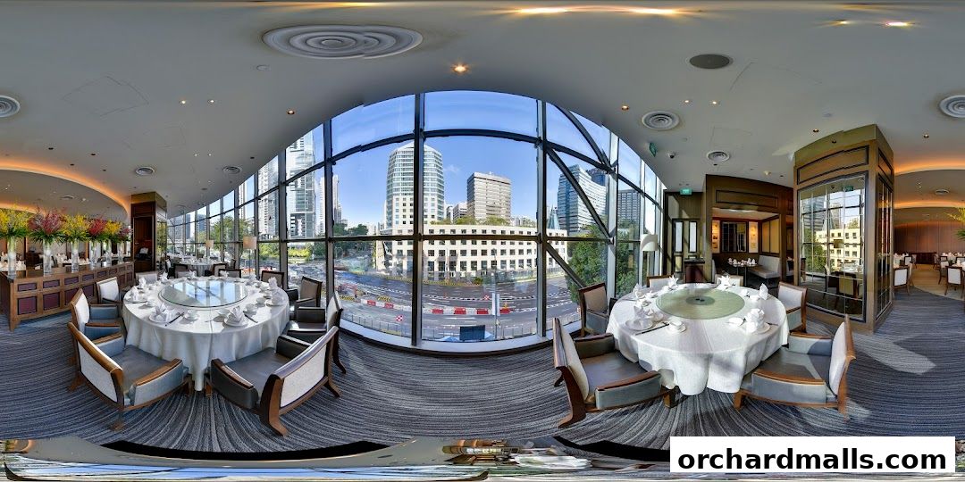 Elegant dining room with round tables set for meals and large windows overlooking a city street.