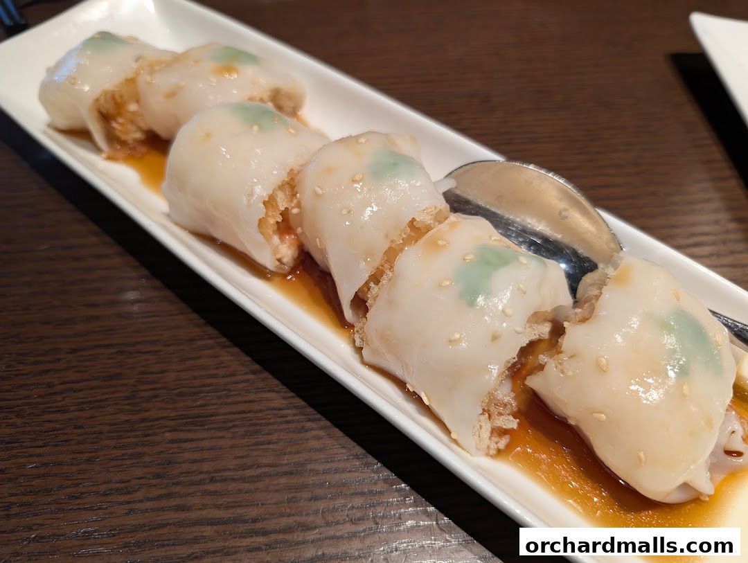 A plate of Teochew-style chee cheong fun (rice noodle rolls) with a savory sauce.