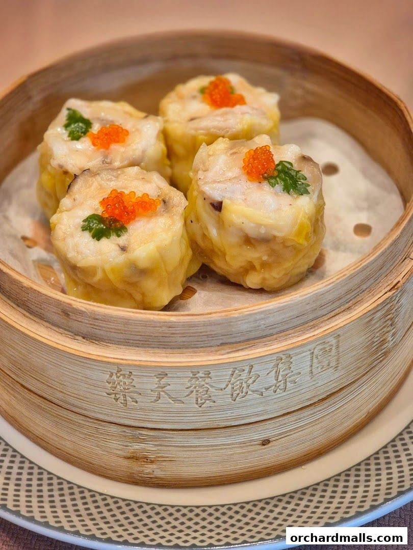 Steamed dim sum with fish roe and parsley in a bamboo steamer.