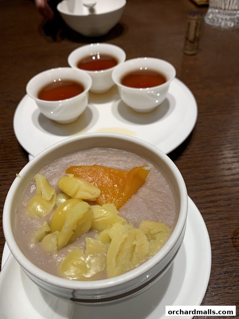 A close-up of a dessert with taro paste, chestnuts, and pumpkin, served with tea.