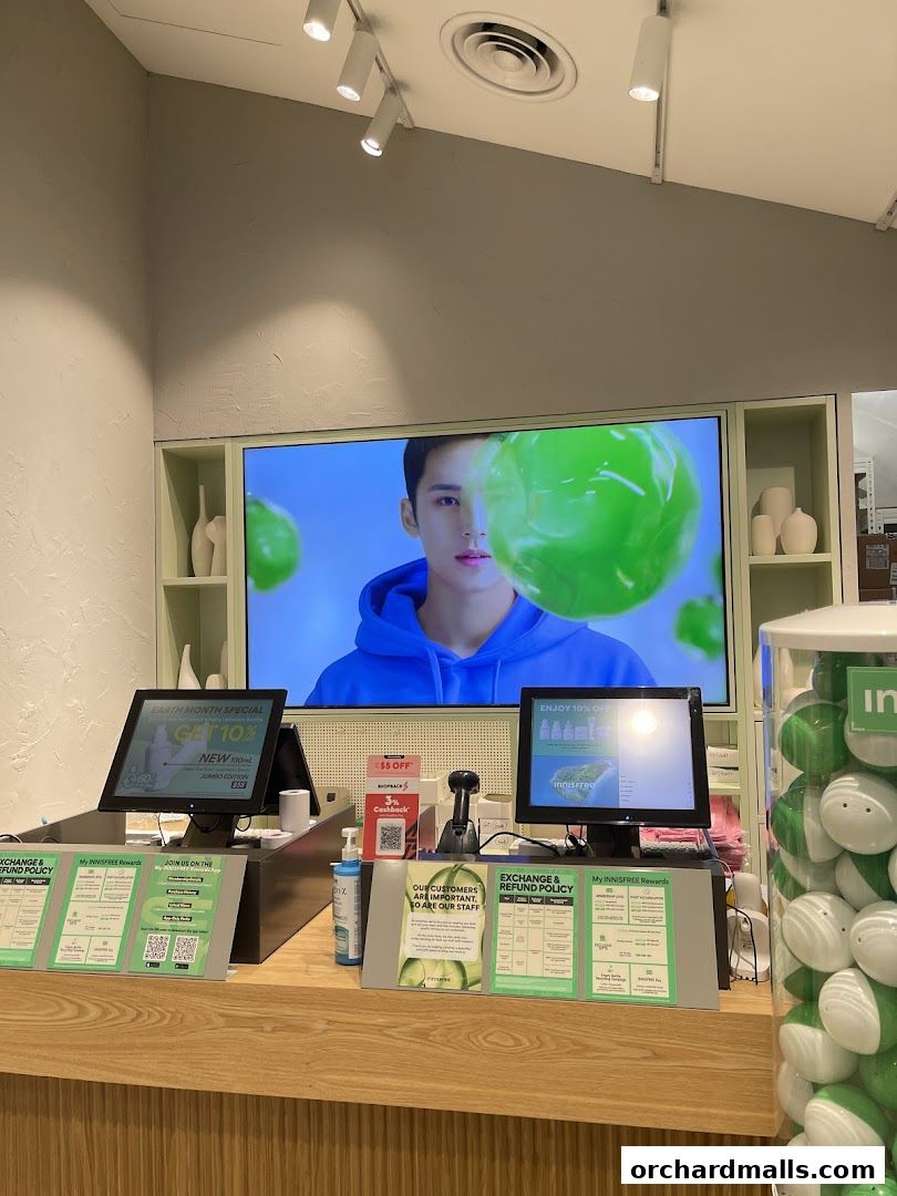 Innisfree store counter with screens, promotions, and product displays.