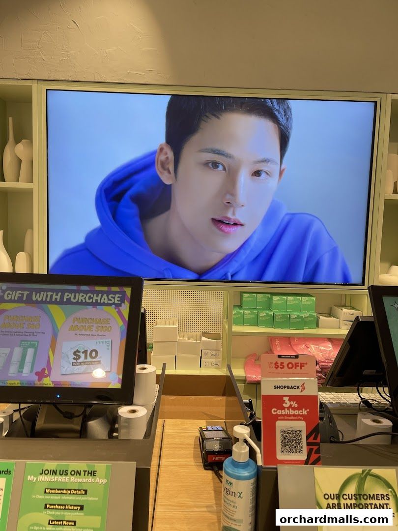 Innisfree store counter with a screen displaying an advertisement and promotional materials.