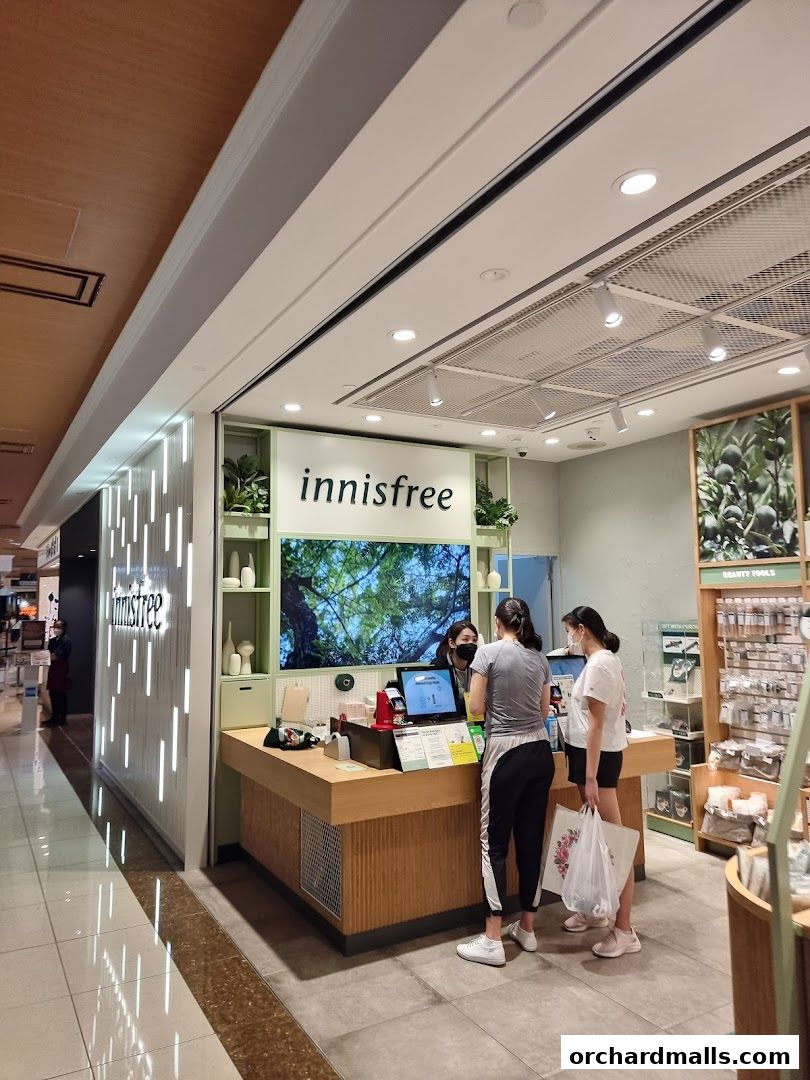 Innisfree store interior with customers at the counter and products on display.