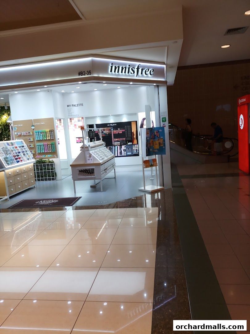 Innisfree store entrance with makeup displays and product shelves.