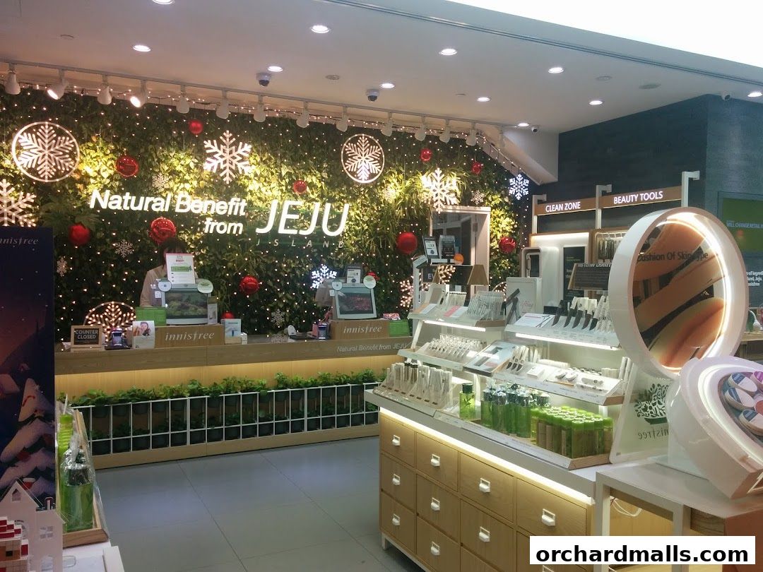 Innisfree store interior with a green wall, product displays, and festive decorations.