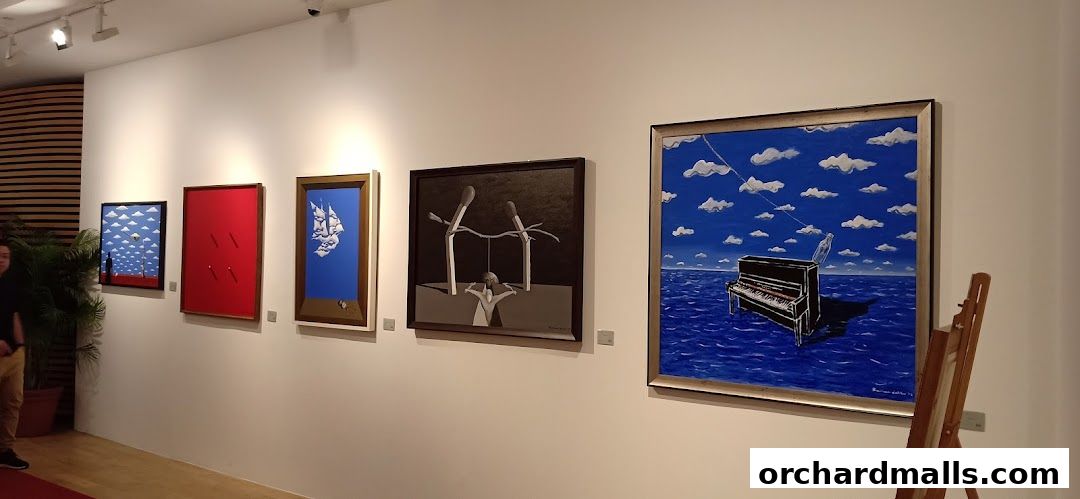 A person walks past a display of surrealist paintings in an art gallery.
