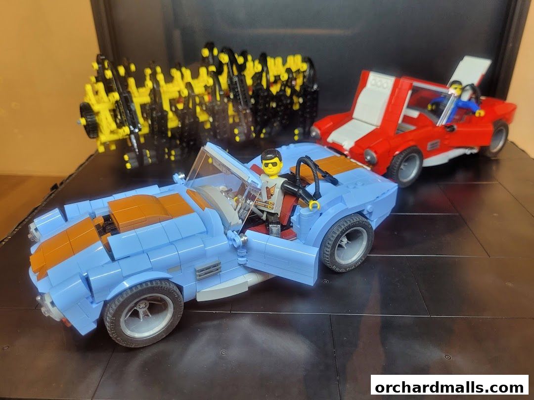 Two Lego cars, one blue and one red, with minifigures inside, displayed on a black surface.