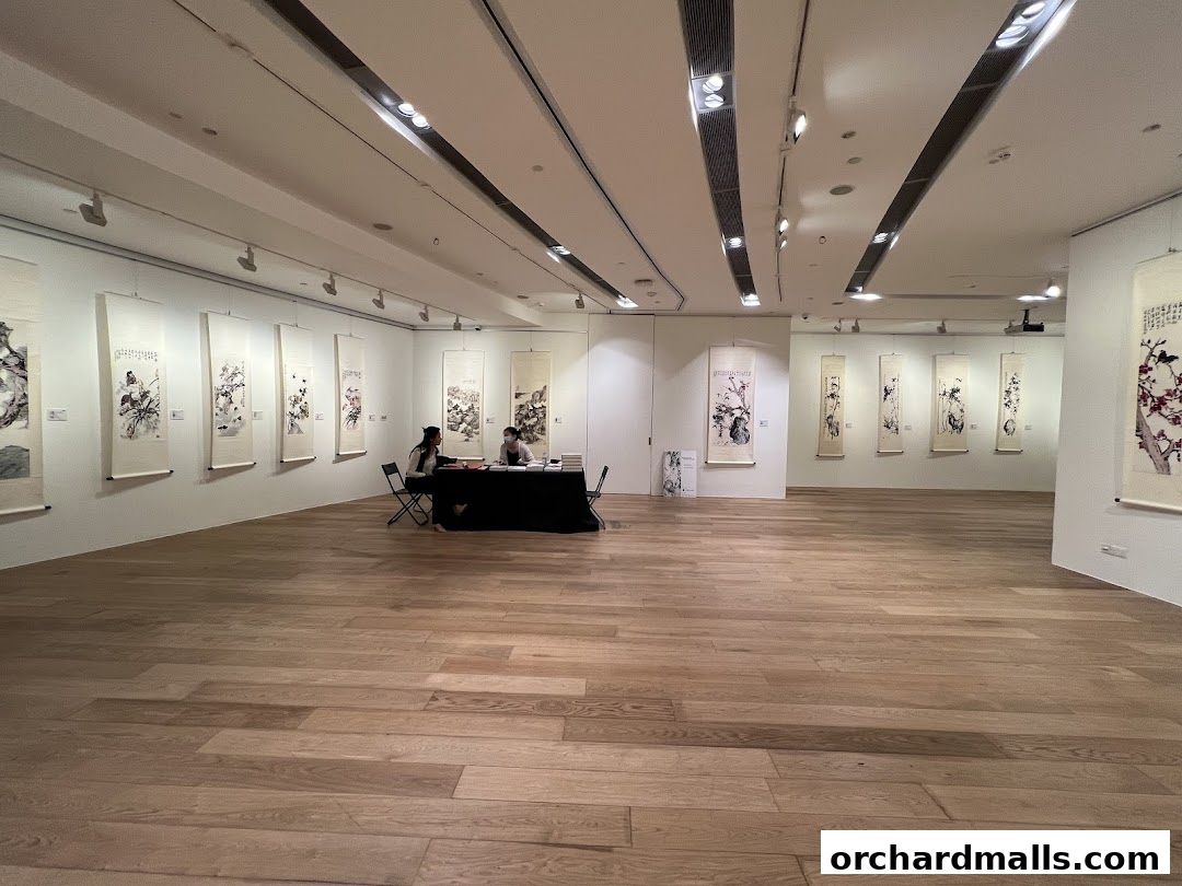 An art gallery interior with traditional Chinese scroll paintings displayed on the walls.