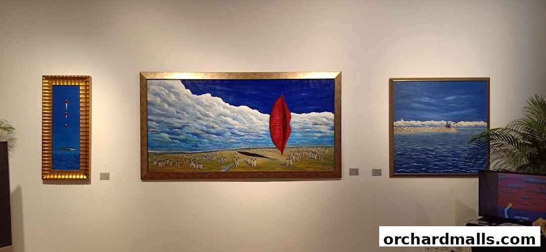 Three framed paintings are displayed on a white wall, with a plant and a television in the foreground.