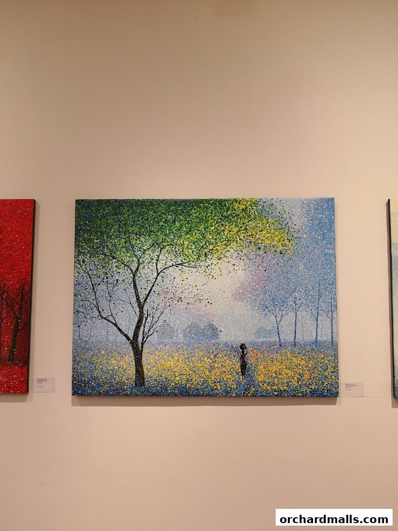 Artwork displayed on a wall, featuring a landscape with trees and a figure.