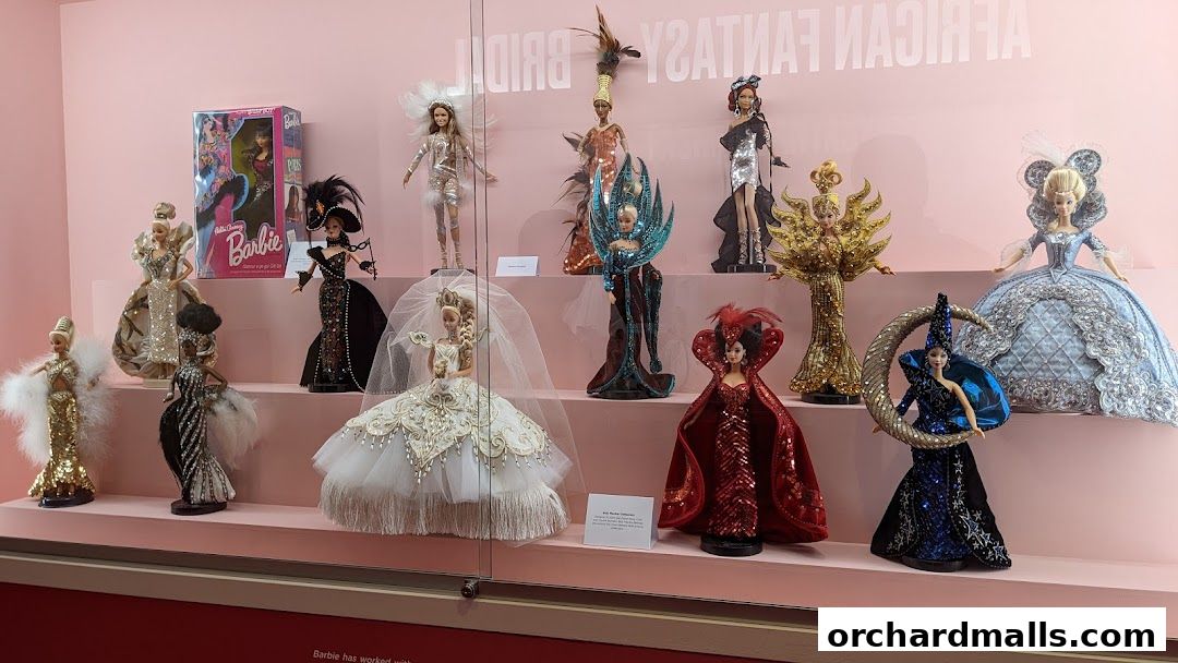 A display of Barbie dolls dressed in elaborate fantasy and bridal gowns.