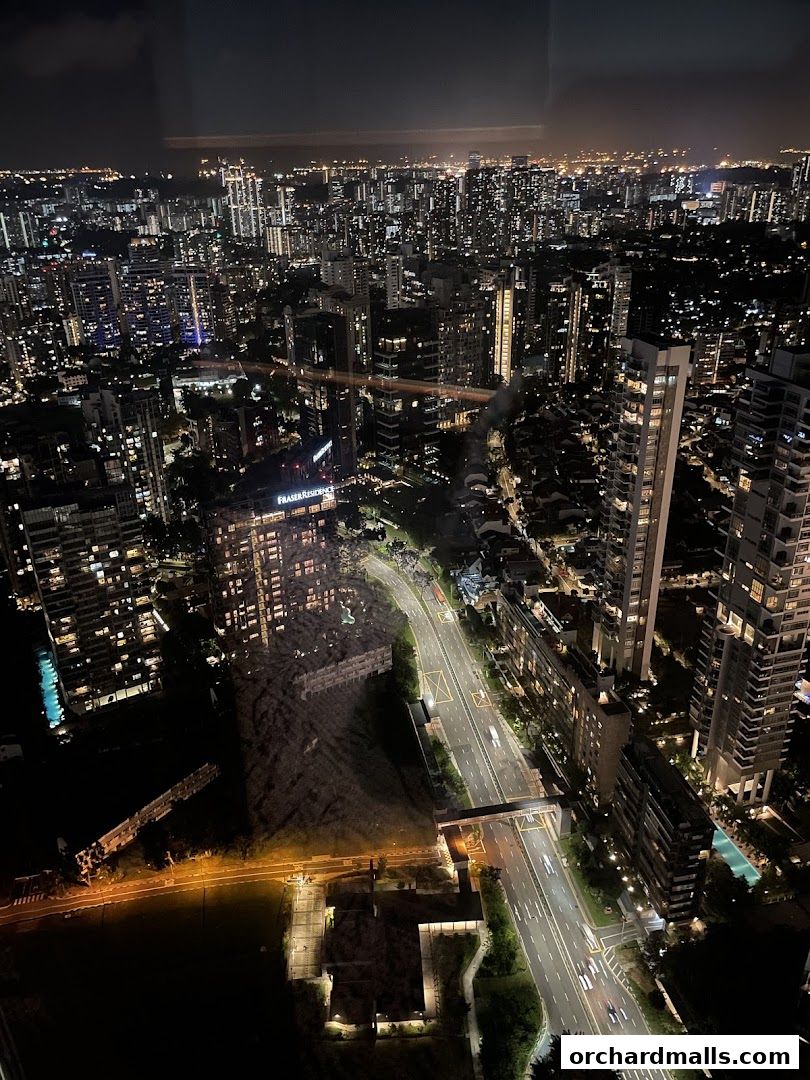 A breathtaking nighttime aerial view of a sprawling cityscape with illuminated skyscrapers and roads.