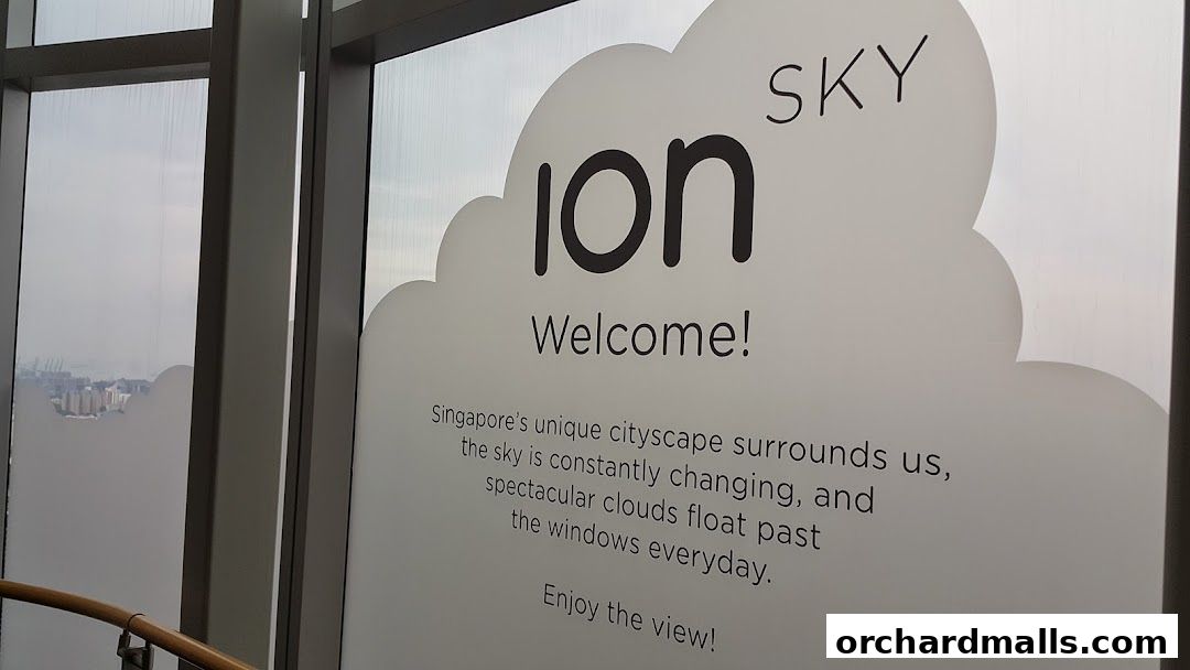 A welcome sign at ION Sky with a view of Singapore's cityscape.