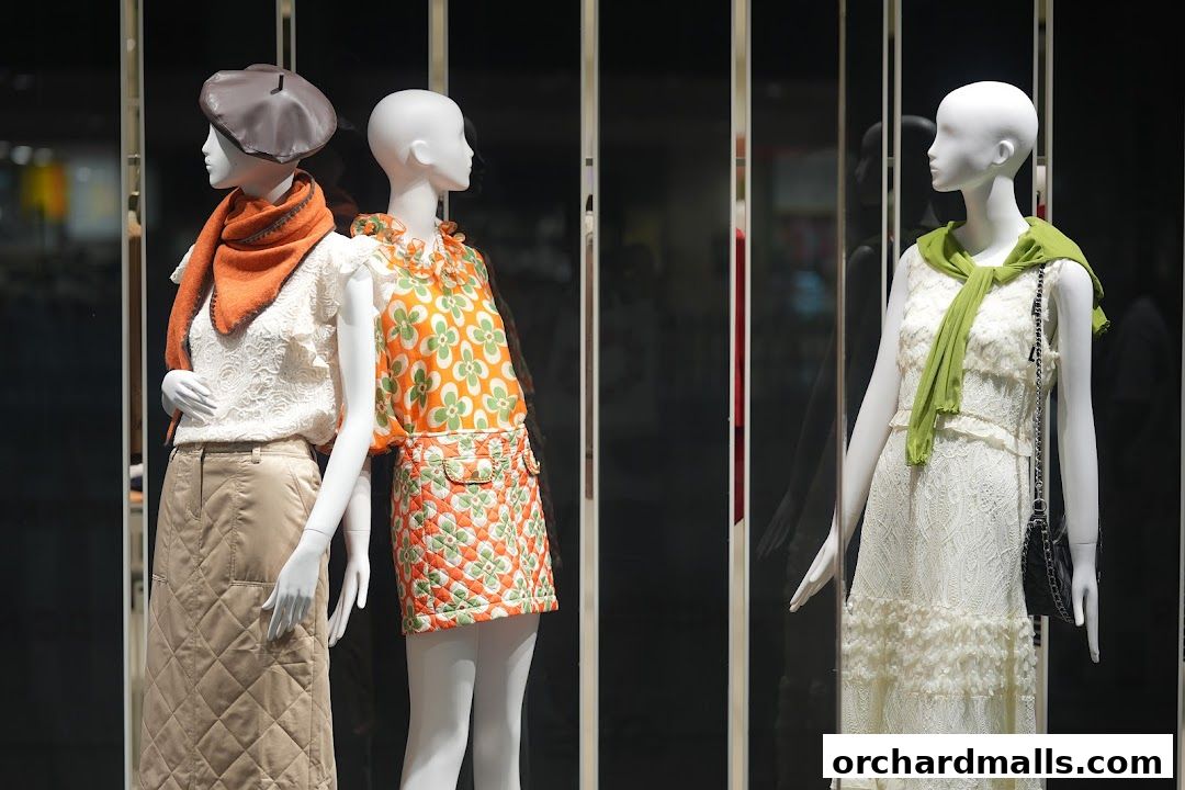 Mannequins display stylish outfits in a shop window, showcasing fashion.