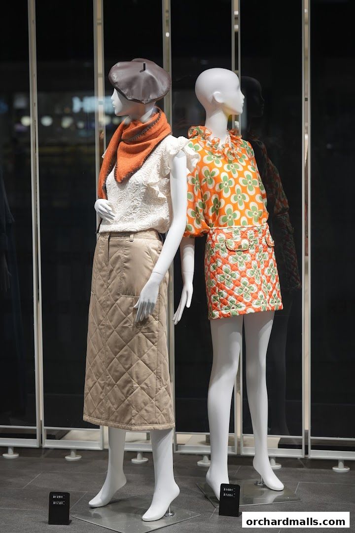 Mannequins display stylish outfits with a quilted skirt and a floral print dress.
