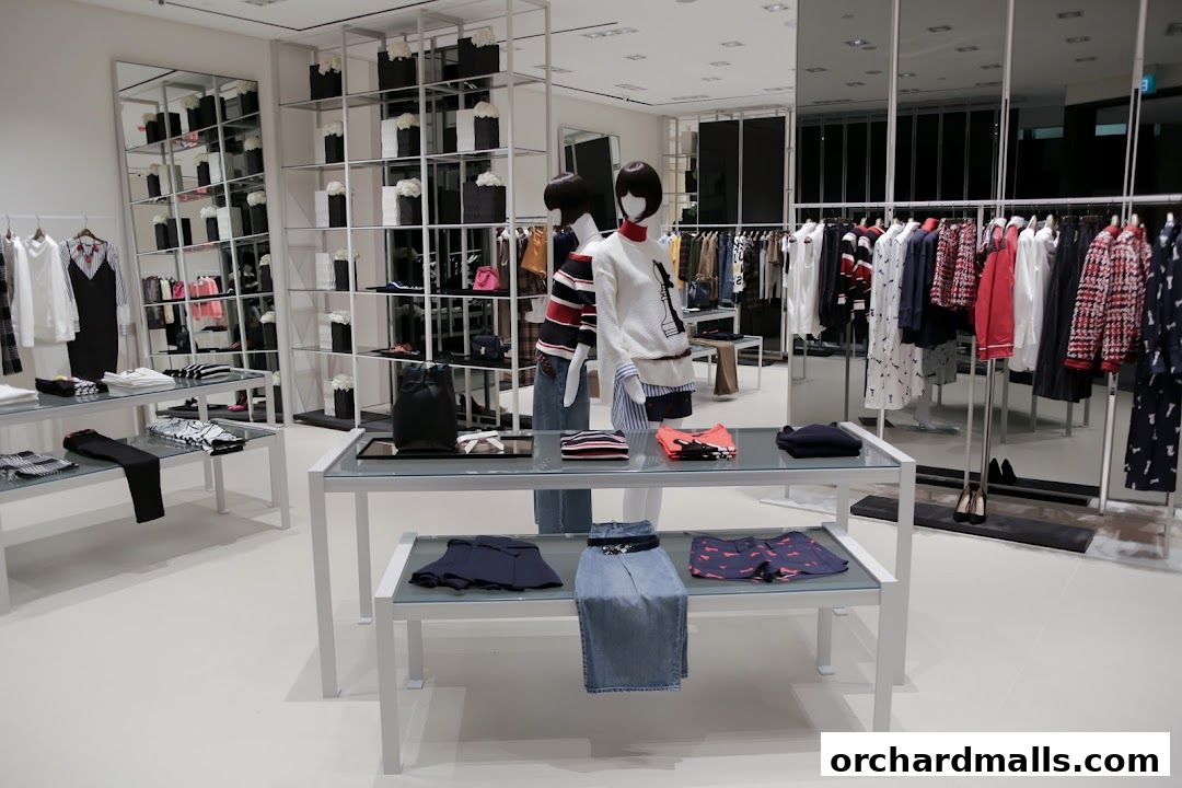 Interior view of a modern clothing store with mannequins and apparel displays.