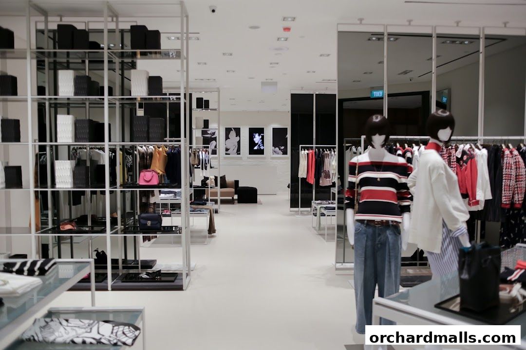 Interior view of a modern clothing store with mannequins and apparel on display.