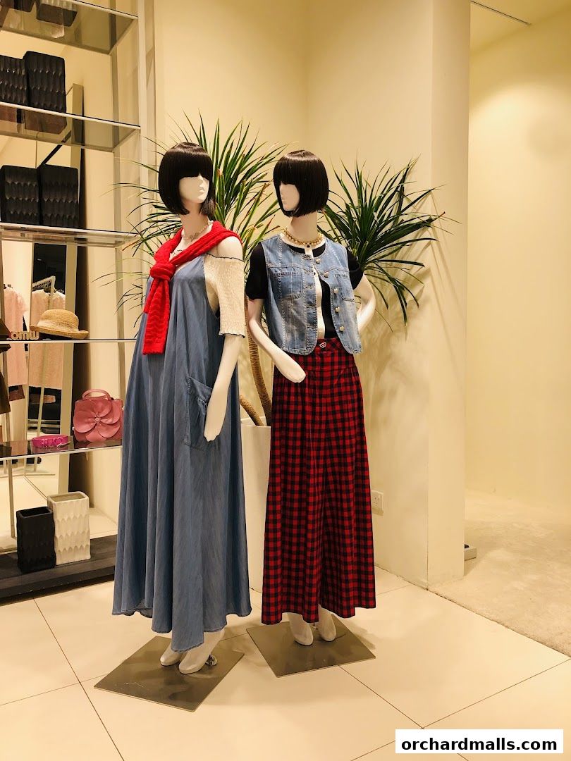 Mannequins display stylish denim and plaid outfits in a well-lit retail store.